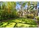 Landscaped backyard with artificial turf and tropical plants at 1854 Amberwynd W Cir, Palmetto, FL 34221