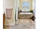 Relaxing bathroom with soaking tub and arched window at 1854 Amberwynd W Cir, Palmetto, FL 34221