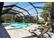 Inviting pool area with screened enclosure, lounge chairs, and brick pavers at 1854 Amberwynd W Cir, Palmetto, FL 34221