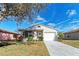 Cute one-story home with a white garage door and landscaped lawn at 20032 Sancraft Ave, Port Charlotte, FL 33954