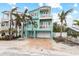 Two-story house with light teal exterior, garage, and palm trees at 203 69Th St # A, Bradenton Beach, FL 34217