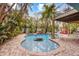 Inviting freeform pool with waterfall feature, surrounded by lush tropical landscaping at 203 69Th St # A, Bradenton Beach, FL 34217