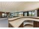 Curved bar in sunroom with wood cabinets and open shelving at 2119 Zipperer Rd, Bradenton, FL 34212