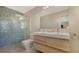 Bathroom with double vanity, mosaic tile shower, and light wood cabinets at 2133 Oriole Dr, Sarasota, FL 34239