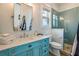 Light and airy bathroom with a teal vanity and walk in shower at 238 Oak Ave, Anna Maria, FL 34216