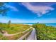 Wooden walkway to beach through lush vegetation at 238 Oak Ave, Anna Maria, FL 34216