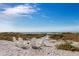 Relaxing beach view with white Adirondack chairs and fire pit at 238 Oak Ave, Anna Maria, FL 34216