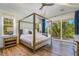 Spacious main bedroom with a wooden four-poster bed and access to a balcony at 238 Oak Ave, Anna Maria, FL 34216