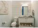 Powder room with white vanity, seashell decor, and shiplap walls at 238 Oak Ave, Anna Maria, FL 34216