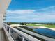 Expansive balcony view of a lush golf course, white sand, and the ocean beyond on a sunny day at 3060 Grand Bay Blvd # 124, Longboat Key, FL 34228