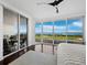 Bright bedroom featuring a plush rug, comfortable bed, and large windows leading to a balcony with stunning views at 3060 Grand Bay Blvd # 124, Longboat Key, FL 34228