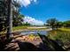 Scenic golf course view with a water hazard, sand trap, and lush green fairway on a sunny day at 3060 Grand Bay Blvd # 124, Longboat Key, FL 34228