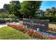 Elegant signage for Bay Isles Beach Club with vibrant flowers, creating a welcoming entrance at 3060 Grand Bay Blvd # 124, Longboat Key, FL 34228