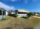 Single-wide manufactured home with carport and landscaped lawn at 308 Danube Cir, Bradenton, FL 34207