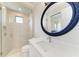 Modern bathroom with a walk-in shower, white vanity, and a large round mirror at 3123 Founders Club Dr, Sarasota, FL 34240