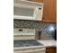 Microwave and stovetop with patterned backsplash at 3453 Parkridge Cir # 18-101, Sarasota, FL 34243