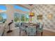 Elegant dining room with round wooden table, blue chairs, and decorative wallpaper at 3598 Fair Oaks Ln, Longboat Key, FL 34228