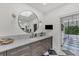 Bathroom features a round mirror, marble countertops, and views of the outdoors at 3709 Beneva Oaks Way, Sarasota, FL 34238