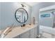 Bright bathroom with a stylish round mirror, modern vanity, and a clean, well-lit space at 3709 Beneva Oaks Way, Sarasota, FL 34238