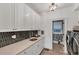 Well-organized laundry room with sleek white cabinetry, black backsplash, modern appliances, and ample counter space at 3709 Beneva Oaks Way, Sarasota, FL 34238