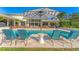 Relaxing poolside view with comfortable lounge chairs and striped umbrella at 3709 Beneva Oaks Way, Sarasota, FL 34238