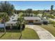 Ranch style home with circular driveway, green lawn and palm trees at 372 Tihami Rd, Venice, FL 34293