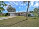 Tan single-story house with a curved driveway, attached garage, and lush lawn at 372 Tihami Rd, Venice, FL 34293