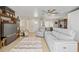 Living room with gray reclining sofas, wood shelving, and tiled floors at 372 Tihami Rd, Venice, FL 34293