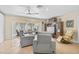 Living room with gray reclining sofas, sliding glass doors, and tiled floors at 372 Tihami Rd, Venice, FL 34293