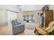 Living room with gray reclining sofas, sliding glass doors, and tiled floors at 372 Tihami Rd, Venice, FL 34293