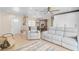 Living room with gray reclining sofas, wood shelving, and tiled floors at 372 Tihami Rd, Venice, FL 34293