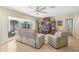 Living room with gray reclining sofas, sliding glass doors, and tiled floors at 372 Tihami Rd, Venice, FL 34293