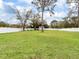 Large grassy backyard featuring a storage shed and surrounded by a white fence at 3822 Ironwood Ct, Sarasota, FL 34243