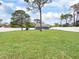 Expansive grassy backyard with white fence, mature trees, and view of the screened porch at 3822 Ironwood Ct, Sarasota, FL 34243