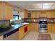 Well-lit kitchen showcasing wood cabinets, tile floors, stainless steel appliances and dark countertops at 3822 Ironwood Ct, Sarasota, FL 34243