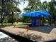 Community playground shaded by a blue canopy, providing a fun outdoor activity area at 3822 Ironwood Ct, Sarasota, FL 34243