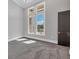 Bright bedroom with grey carpet, multiple windows, and a dark door at 3927 Founders Club Dr, Sarasota, FL 34240