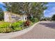 The Founders Club entrance with lush landscaping and brick pavers at 3927 Founders Club Dr, Sarasota, FL 34240