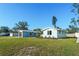 View of the home's exterior with a green lawn, blue paint, detached garage, and new landscaping at 3952 Coleridge Pl, Sarasota, FL 34241