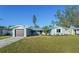 Charming single-story home with a well-manicured lawn, blue paint, and a detached garage at 3952 Coleridge Pl, Sarasota, FL 34241