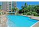 Inviting resort-style pool with ample lounge space and palm trees at 401 N Point Rd # 401, Osprey, FL 34229