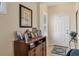 Bright entryway with a console table, framed photos, and white door at 4121 Deep Creek Ter, Parrish, FL 34219