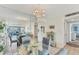 Dining area features a glass table, four chairs, and a mirrored wall reflecting the living room at 4350 Chatham Dr # 106, Longboat Key, FL 34228