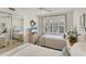 Bright guest bedroom with two twin beds, mirrored closet, and large window at 4350 Chatham Dr # E106, Longboat Key, FL 34228