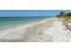 White sand beach with ocean view and condo in background at 455 Longboat Club Rd # 305, Longboat Key, FL 34228