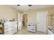 Well-lit bedroom with a dresser, changing table, and access to hallway at 4850 51St W St # 9106, Bradenton, FL 34210