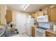 Well-lit kitchen featuring wood cabinets and white appliances at 4850 51St W St # 9106, Bradenton, FL 34210