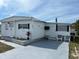 White single-wide manufactured home with small front yard and paved driveway at 4915 Winged Foot Ave, Sarasota, FL 34234