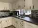 White kitchen with dark countertops, mosaic backsplash, and stainless appliances at 4915 Winged Foot Ave, Sarasota, FL 34234