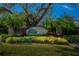 Grande Oaks Preserve entrance with lush landscaping and a stately oak tree at 5250 Manorwood Dr # 4A, Sarasota, FL 34235